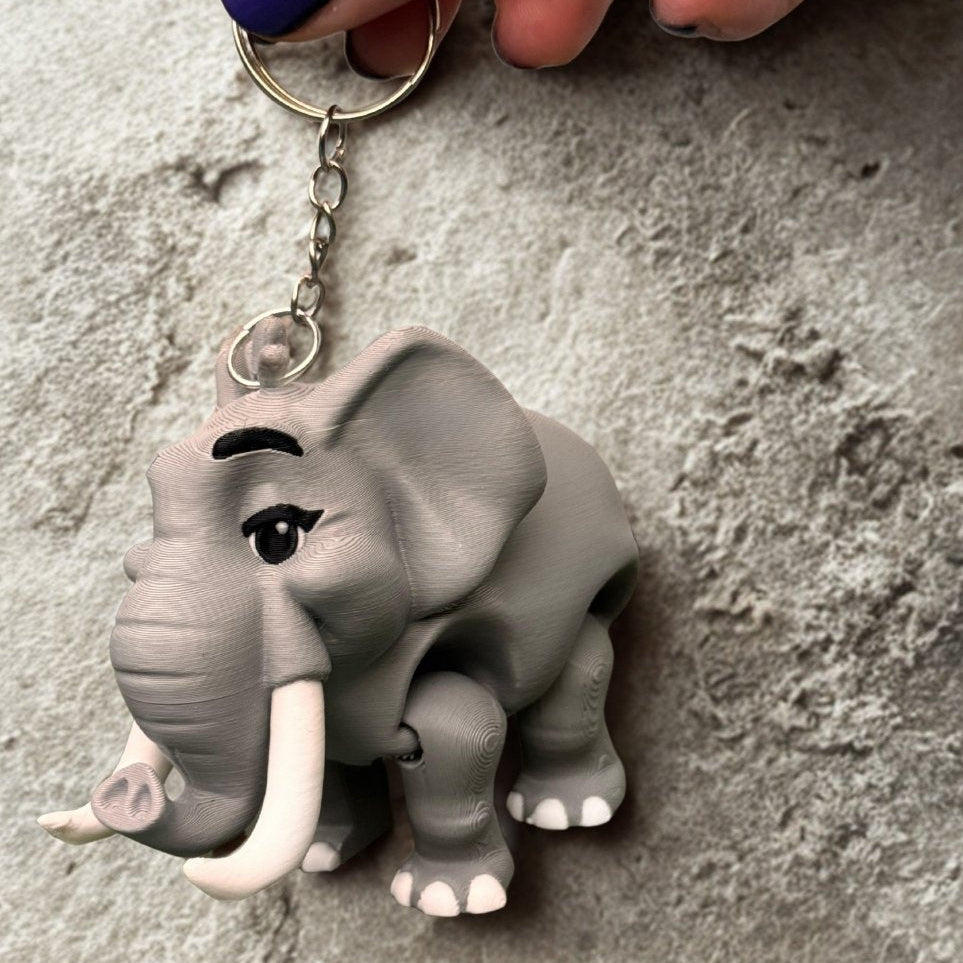 A small gift box lined with tissue paper contains the monkey keychain, ready to be gifted; the box is decorated with a jungle print, perfect for birthdays or special occasions.
