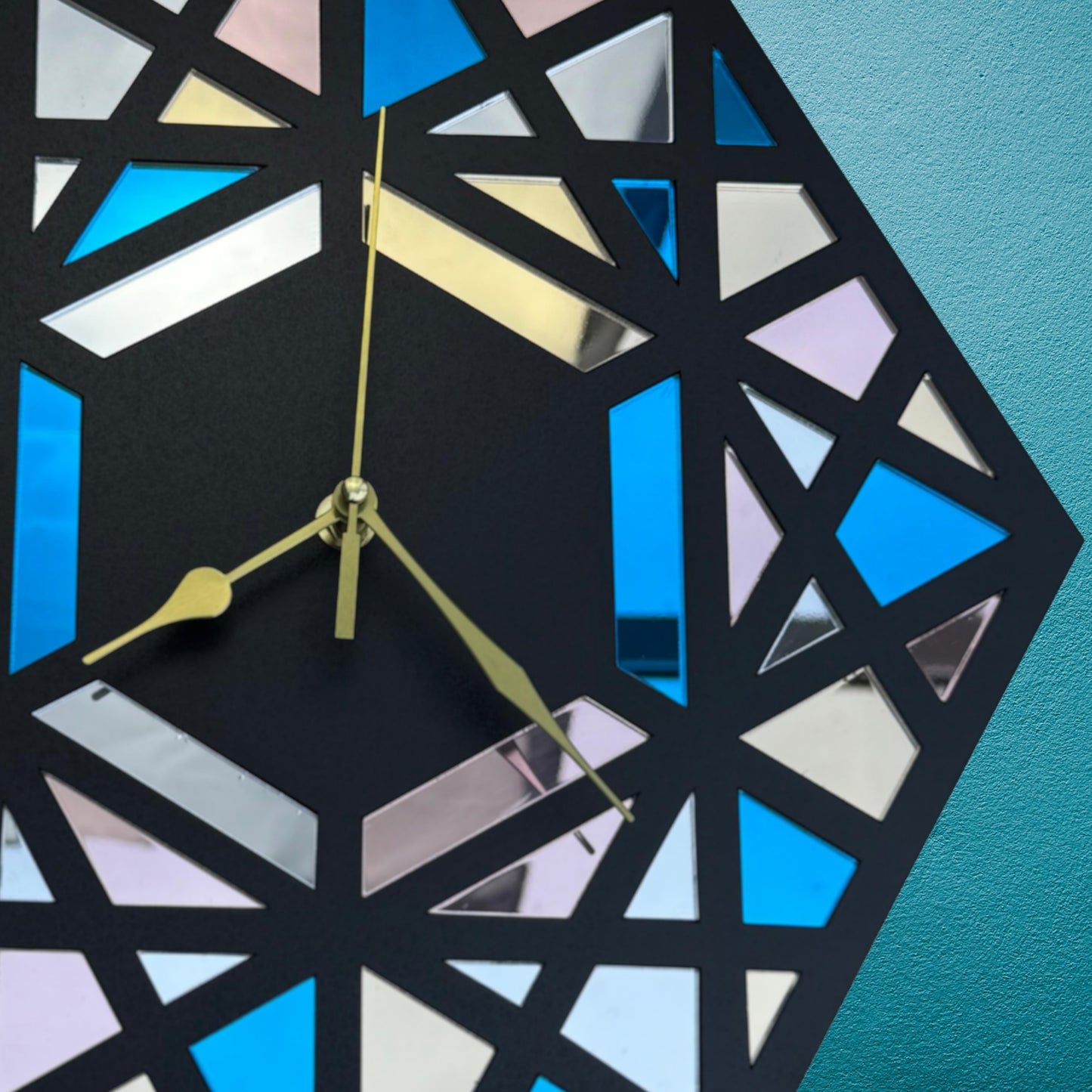 Geometric wall clock with colorful triangles on a blue background