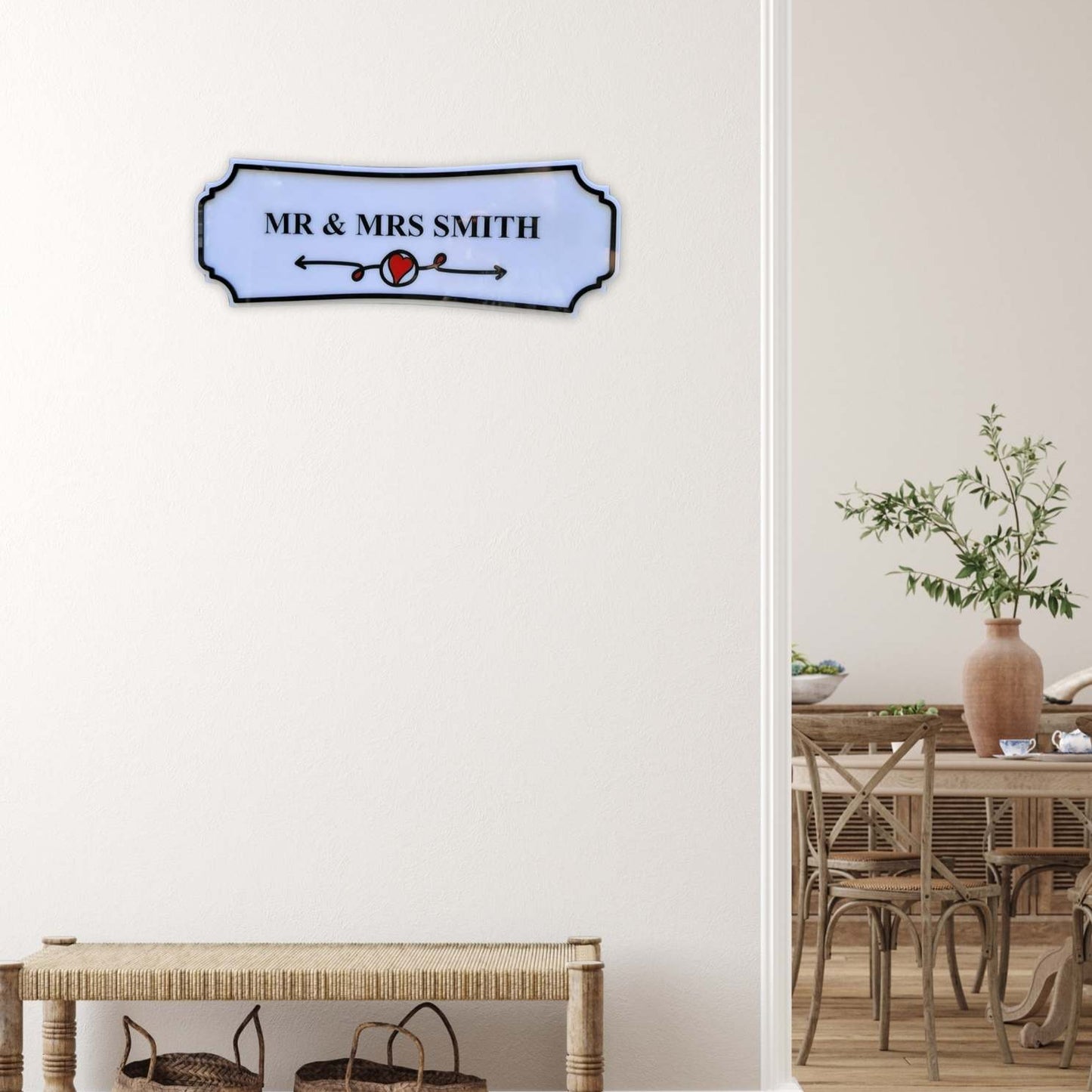 Decorative sign with 'MR & MRS SMITH' on a wall in a room with a table and plants.