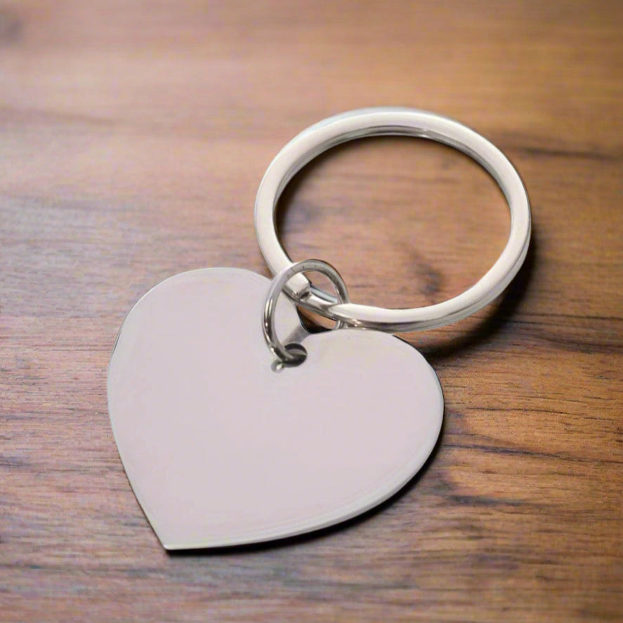 Matching engraved keychains for soulmates or best friends, arranged side by side on a marble table – each inscribed with initials and a shared date, representing connection, loyalty, and time