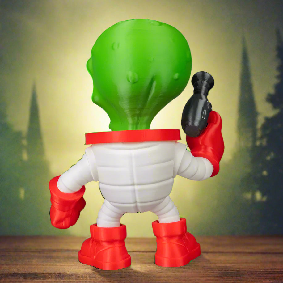 Toy figure with green head, white body, and red shoes on a black background