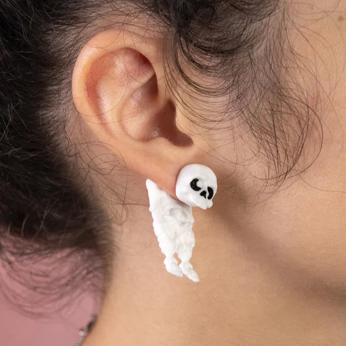 Close-up of skull earrings highlighting their smooth surface, gothic-inspired curves, and playful yet eerie expression ideal for Halloween or costume wear.