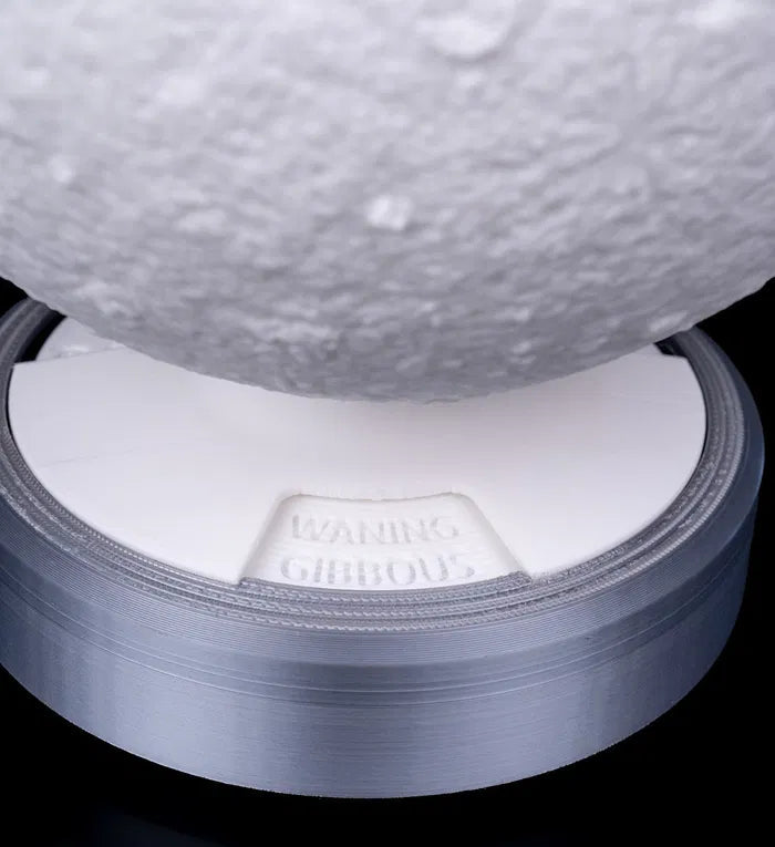 "The lamp mid-rotation showing the transition between phases"
This image captures the lamp being manually rotated, shifting between lunar phases. The transition effect is visible as the light changes, and the engraved phase name subtly shifts on the base.