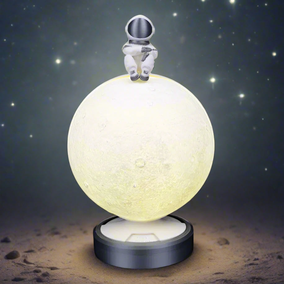 Close-up of the moon lamp showing a waxing crescent phase"
A detailed close-up of the moon lamp in waxing crescent mode. The textured lunar surface glows softly, while the name of the phase is illuminated on the lamp’s base. The little astronaut figure at the top adds a whimsical space-themed touch.