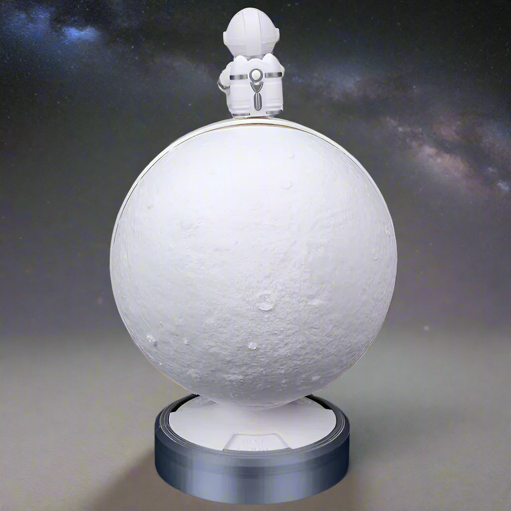 The lamp in a dark room showing the full moon phase glowing brightly"
In a darkened room, the lamp displays a glowing full moon phase. The light spreads warmly around the surrounding area, highlighting the detailed moon texture and the astronaut figure perched on top.