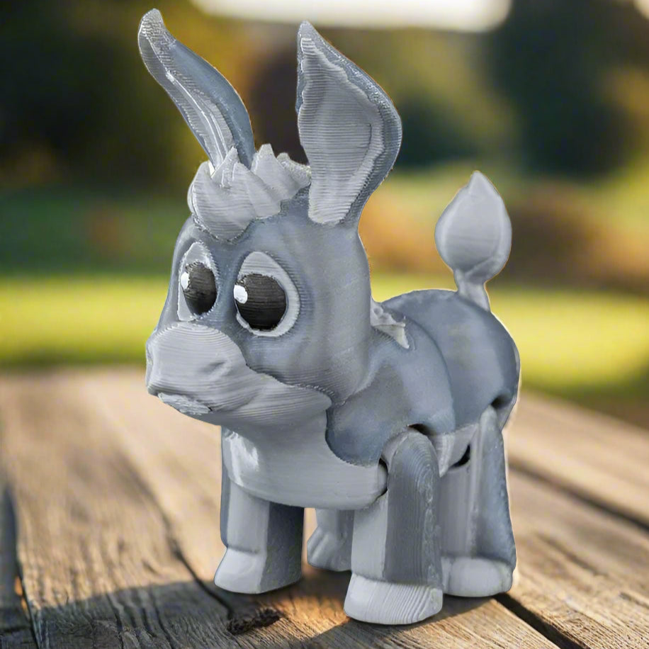 Donkey keychain in motion, swinging slightly on a zipper pull. The lightweight build and secure clip make it ideal for backpacks or pencil cases.