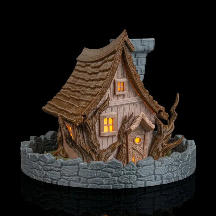 Decorative miniature house with stone base on a black background