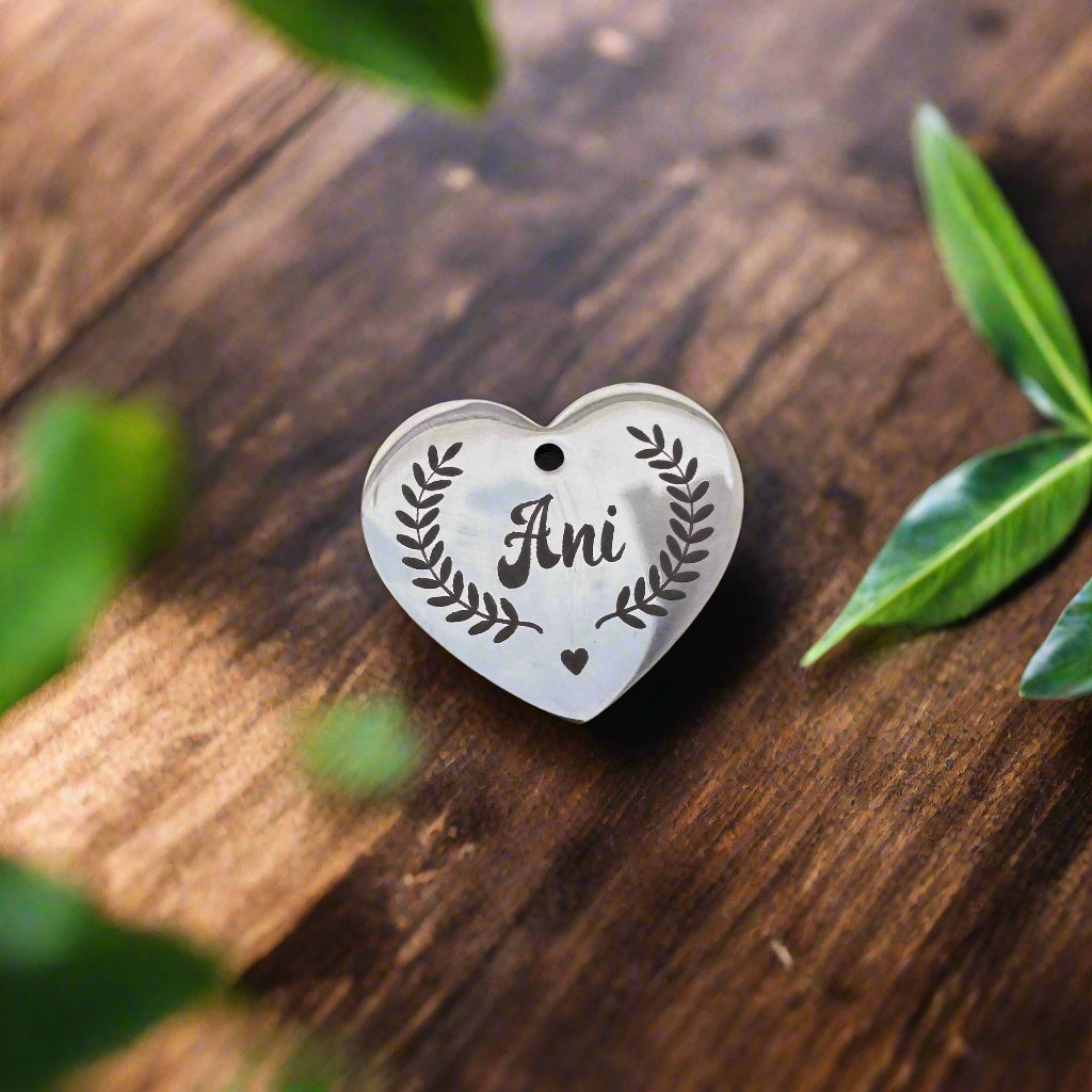 Two custom engraved heart pendants resting on a rustic wooden surface, each with names of a couple in cursive font – symbolizing deep love, connection, and the beauty of shared memories kept close every day