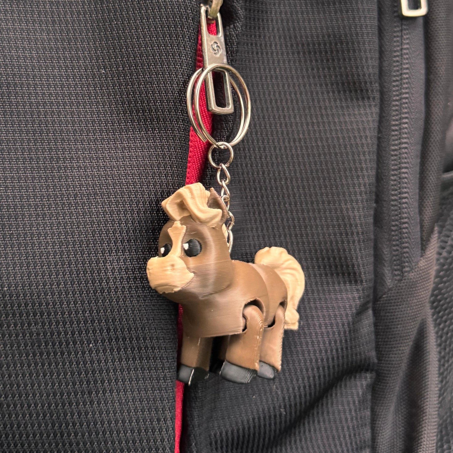 Horse keychain displayed on a wooden surface, with upright posture and flowing mane. Detailed yet playful, this charm is great for animal lovers of all ages.