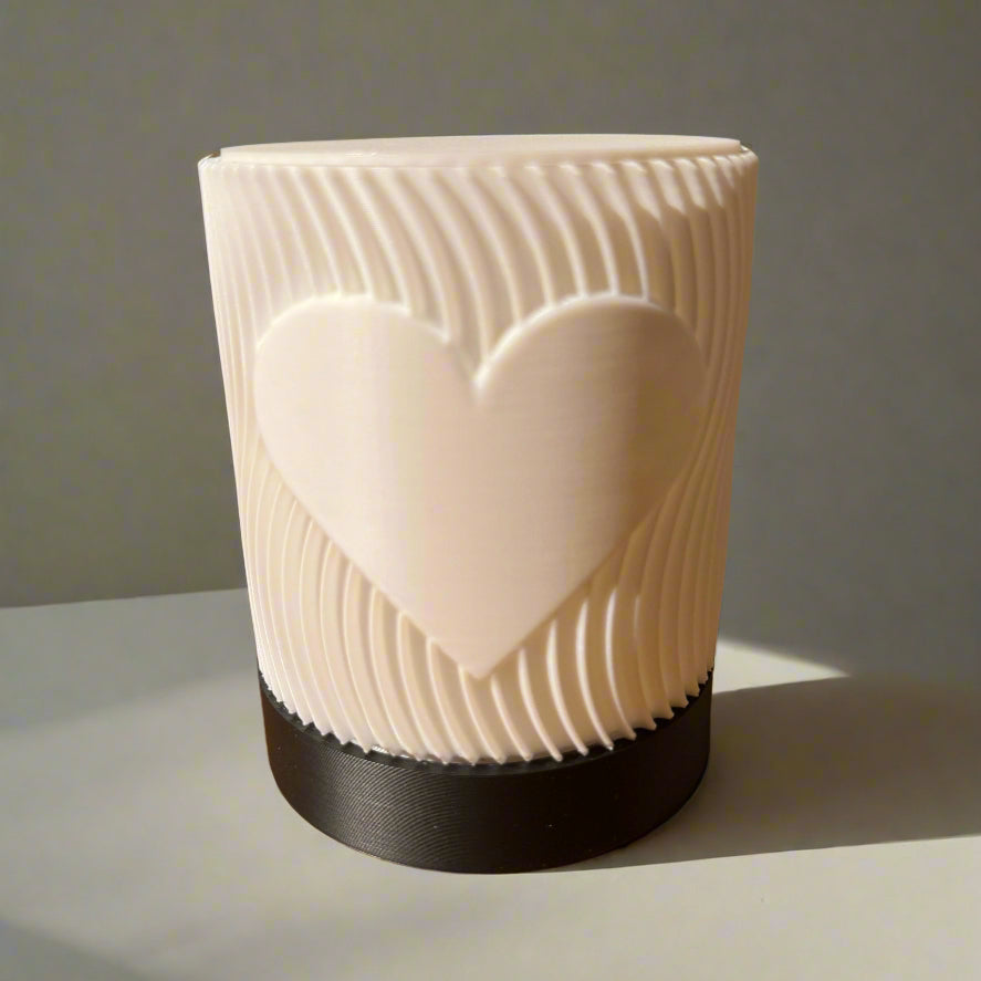 White textured vase with a heart design on a wooden table
