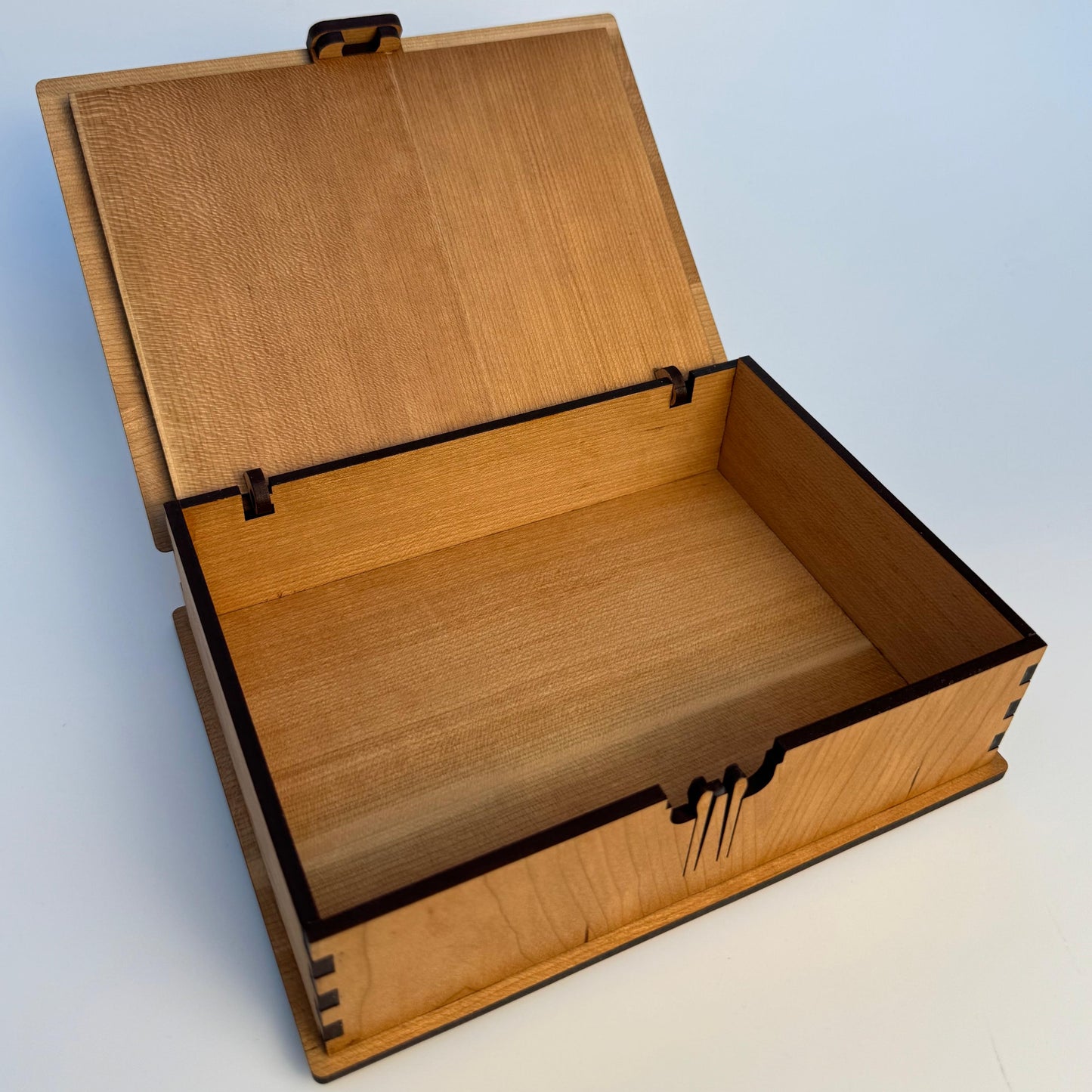 Wooden box with a hinged lid on a light blue background