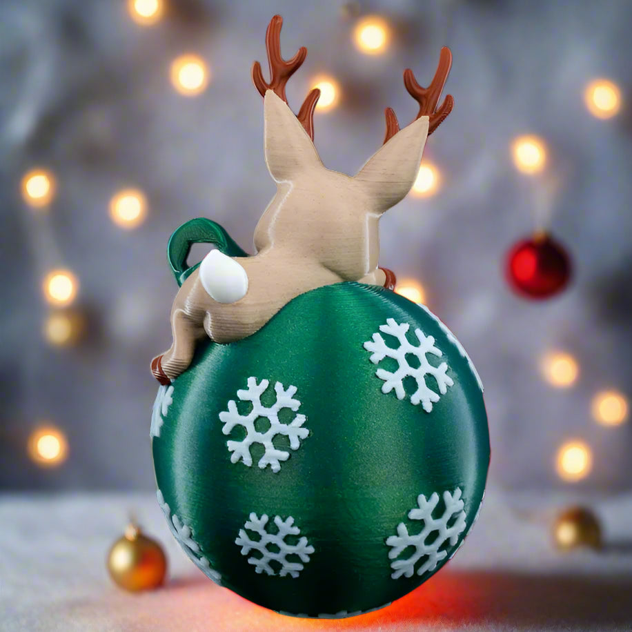Lying Reindeer ornament featuring playful pose on Christmas globe