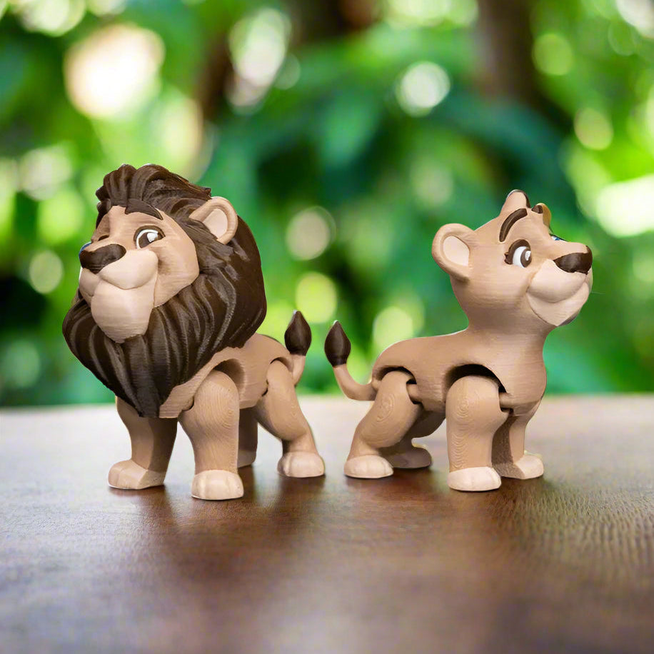 Stylized photo of the lion couple keychains with a colorful, jungle-inspired background. The scene captures the playful spirit of the design, with tropical leaves and fun accessories adding to the joyful, imaginative tone.
