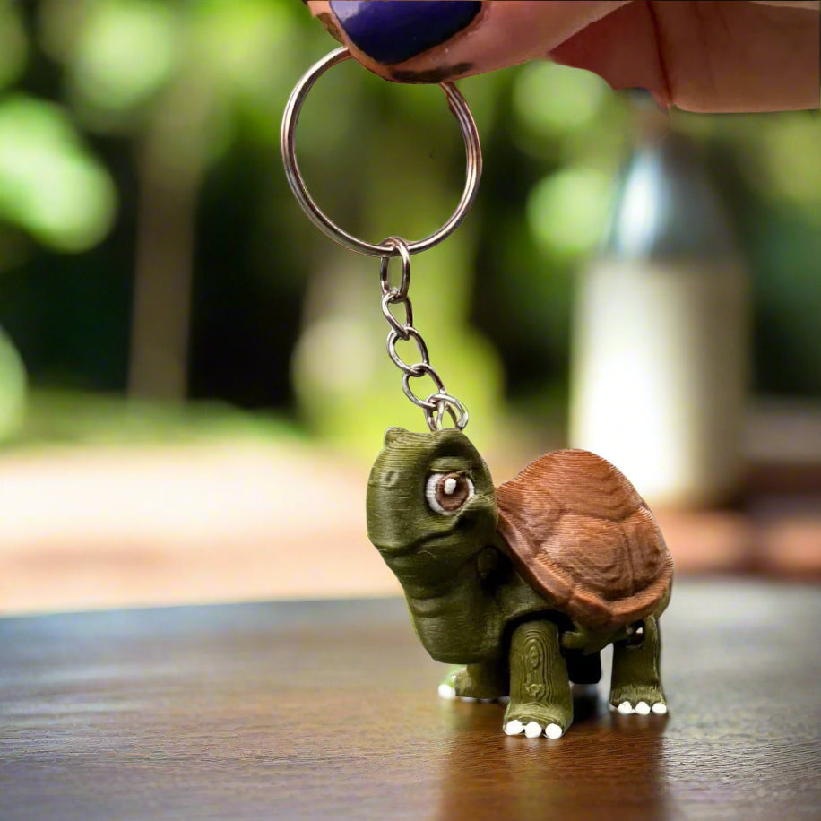 Turtle keychain being held in a child’s hand, illustrating its compact size, friendly look, and soft curves designed for comfort and charm.