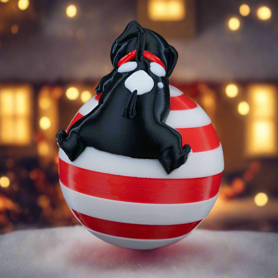 Side view of the Sleeping Dog ornament hanging on a Christmas tree