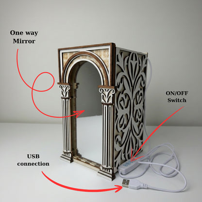 A decorative rectangular mirror with an ornate classical column design, shown with red annotation arrows and labels pointing to the one-way mirror face, USB connection, and on/off switch.
