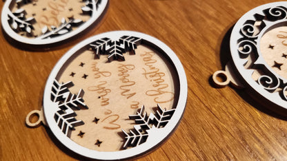 Close-up of a wooden ornament engraved with "Joy to the World" with a festive border.