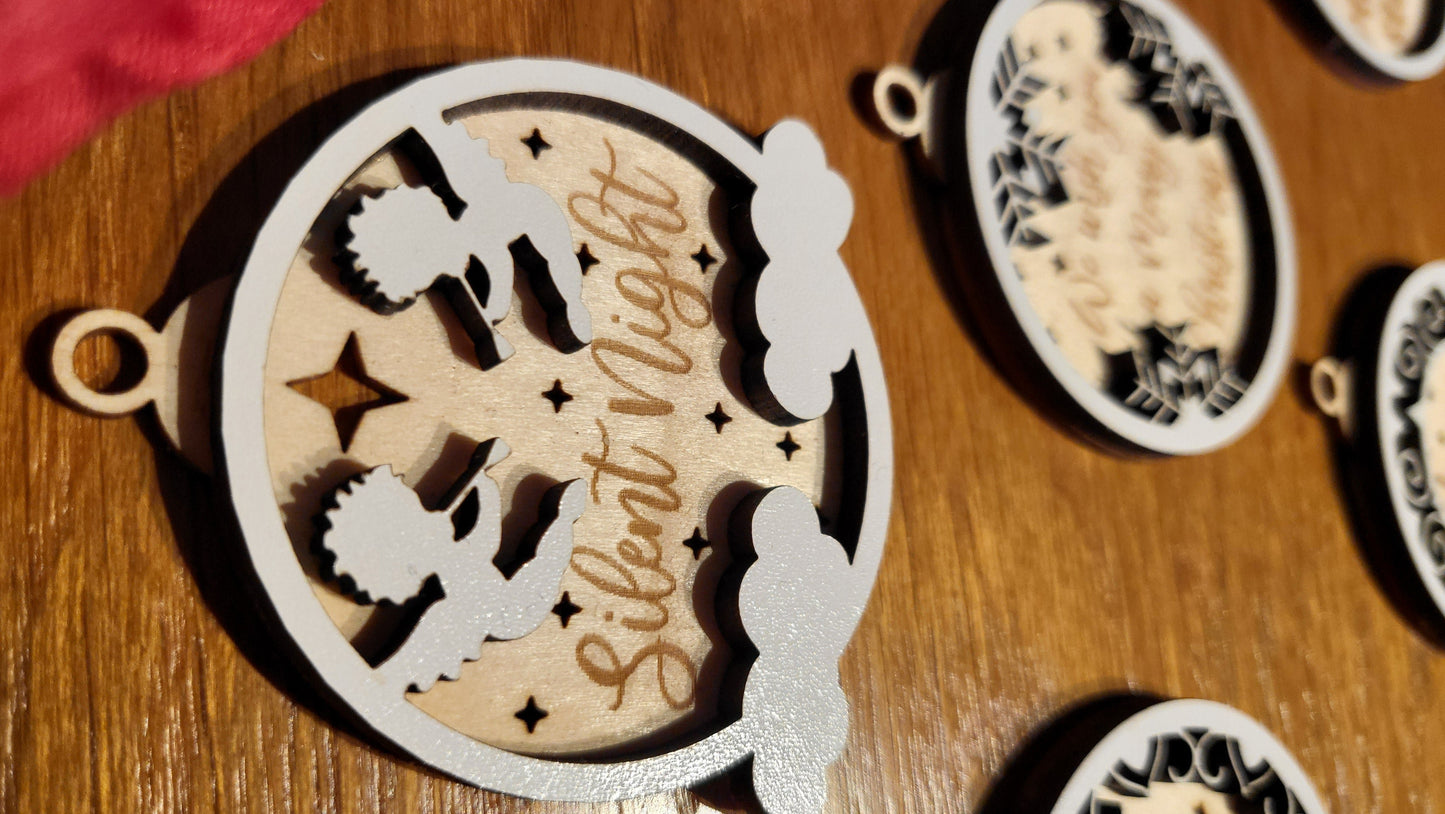 Close-up of a wooden ornament engraved with "Joy to the World" with a festive border.