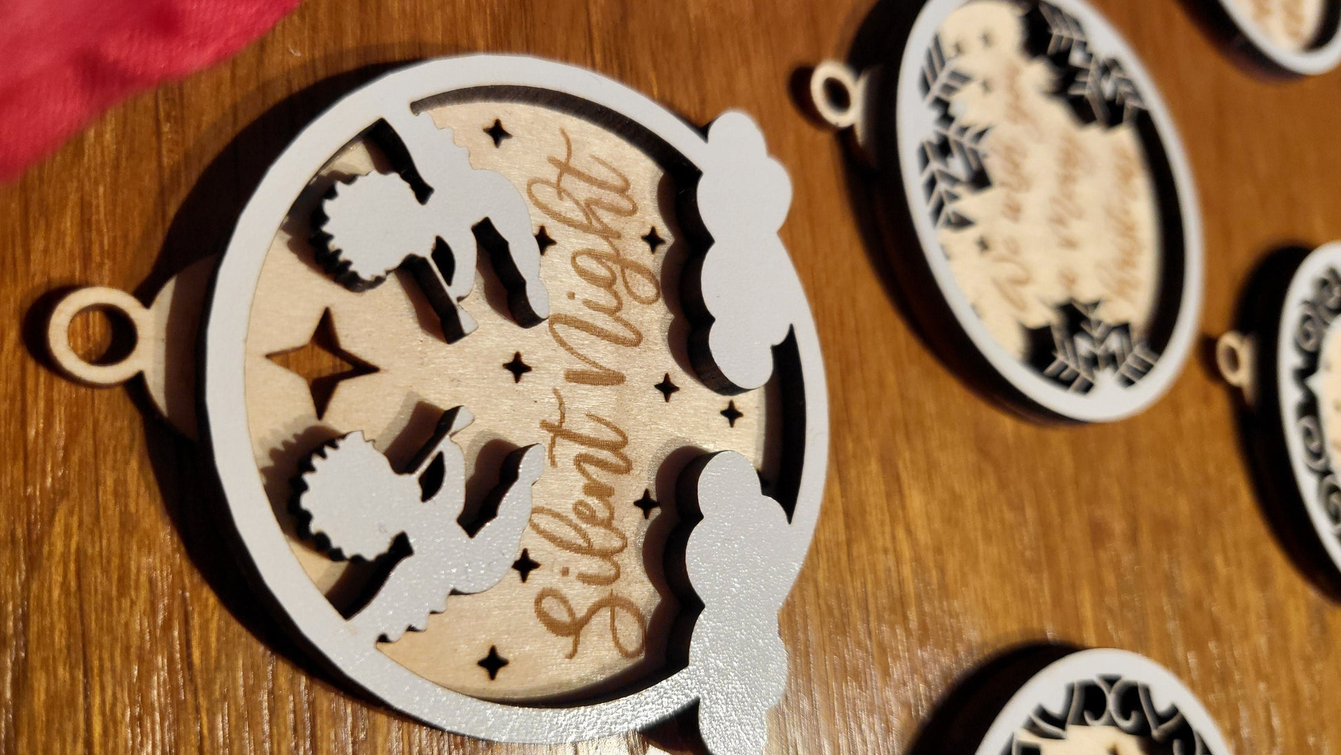 Close-up of a wooden ornament engraved with "Joy to the World" with a festive border.