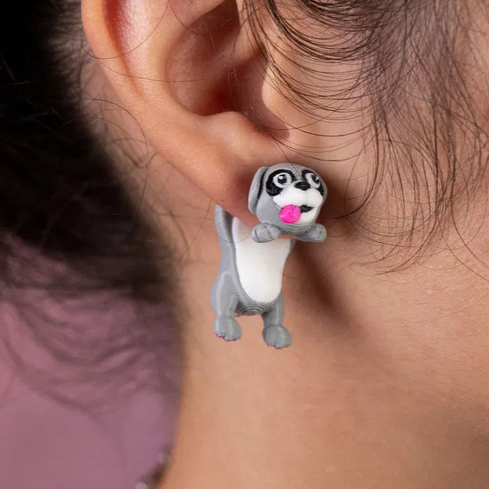 Cat earrings sitting on a ceramic dish shaped like a paw print, with soft daylight and cozy vibes.