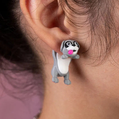 Cat earrings sitting on a ceramic dish shaped like a paw print, with soft daylight and cozy vibes.