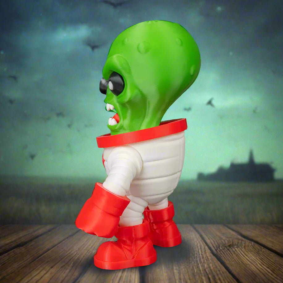 Toy figure of a green alien with red boots on a black background
