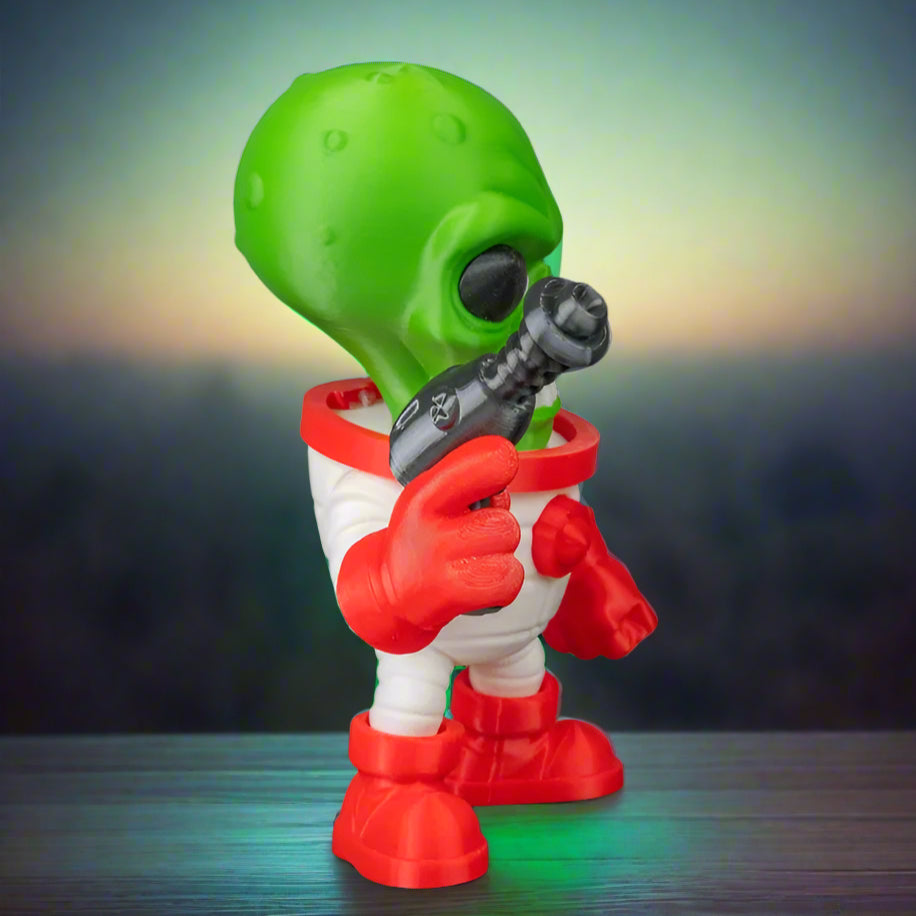 Toy figure of an alien holding a gun on a black background