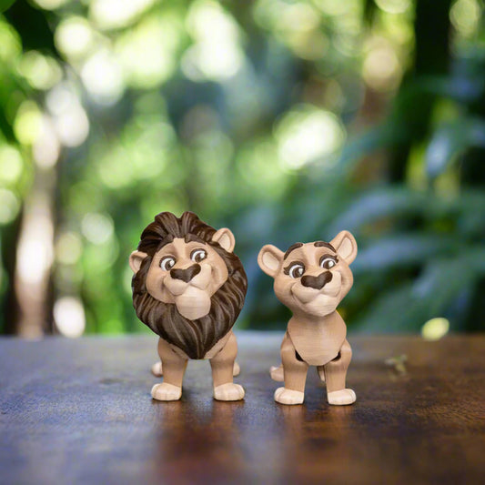 A pair of 3D-printed lion keychains, one male and one female, sit side by side on a light wooden surface. Their intricate details, from tiny facial features to textured manes, are clearly visible, showcasing the quality of the craftsmanship. Perfect for animal lovers and collectors alike.
