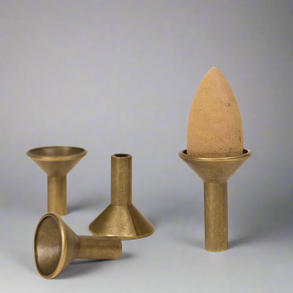 Set of bronze cone-shaped objects on a beige background