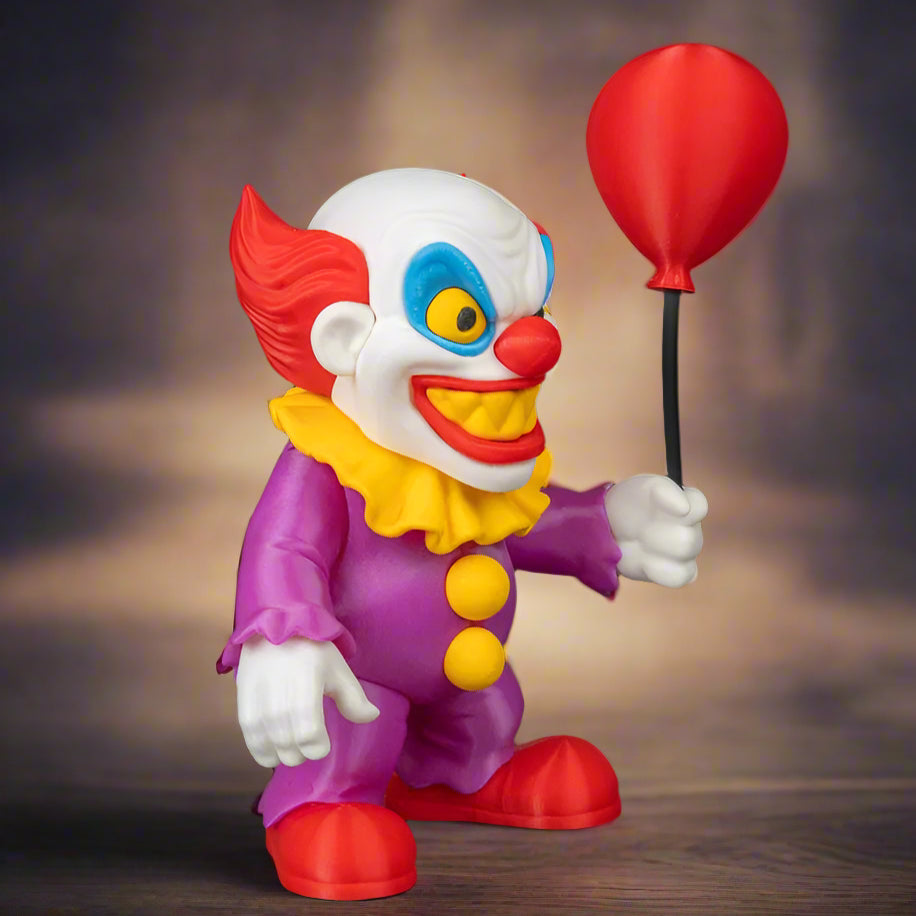 Colorful clown figurine holding a red balloon against a black background