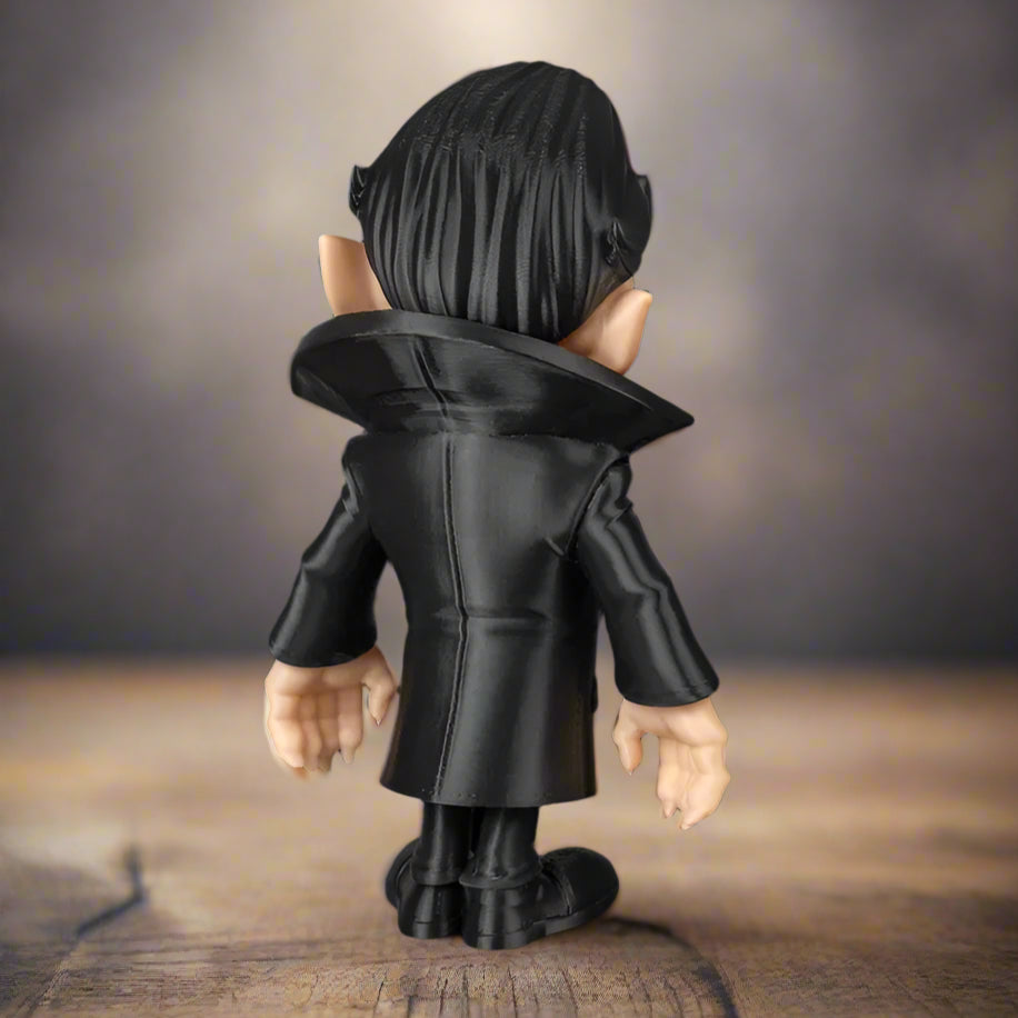 Figurine wearing a black coat on a wooden surface with a blurred background