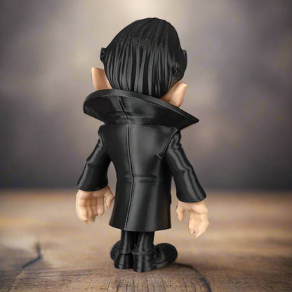 Figurine wearing a black coat on a wooden surface with a blurred background