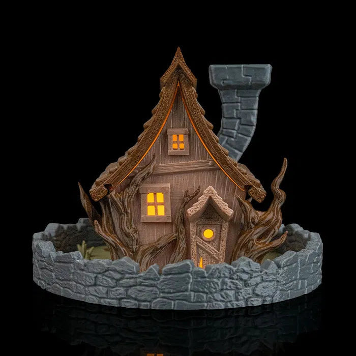 Decorative miniature house with a dark roof and stone base on a black background
