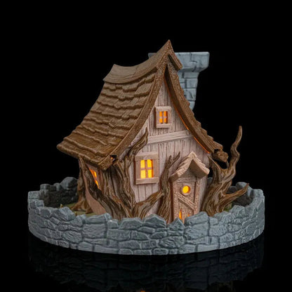 Decorative miniature house with stone base on a black background