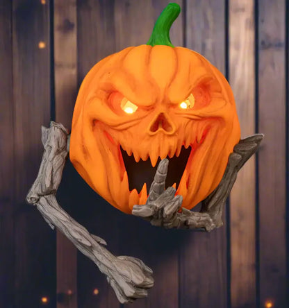 Halloween pumpkin with carved face and skeleton hands on a black background