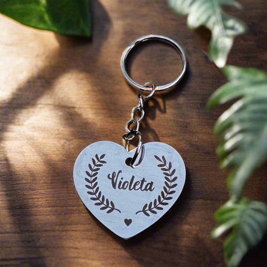 A close-up of a heart-shaped stainless steel keychain lying on a linen cloth, engraved with a pet’s name and a tiny paw print, reflecting soft natural light – a simple and emotional tribute to a beloved animal companion
