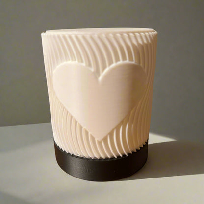 White textured vase with a heart design on a wooden table