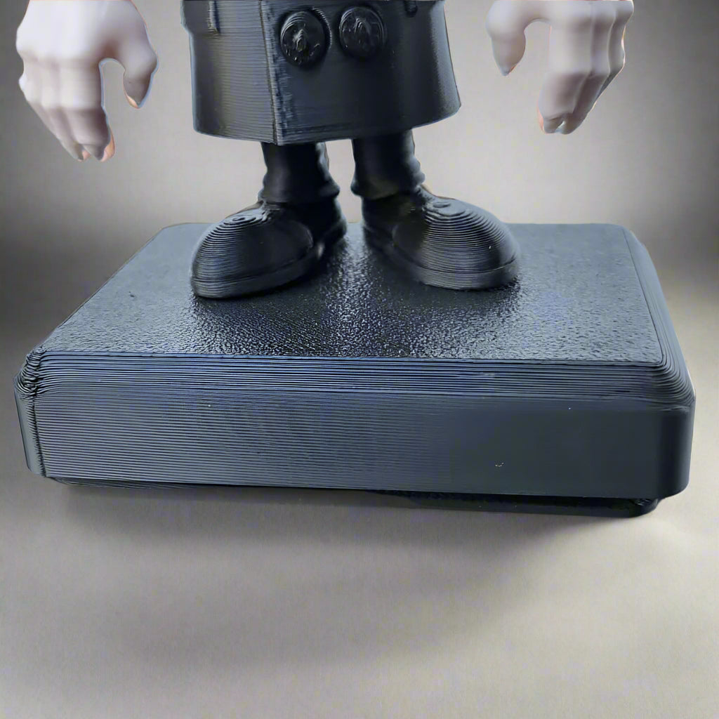 Black 3D-printed figure on a matching base with a plain background
