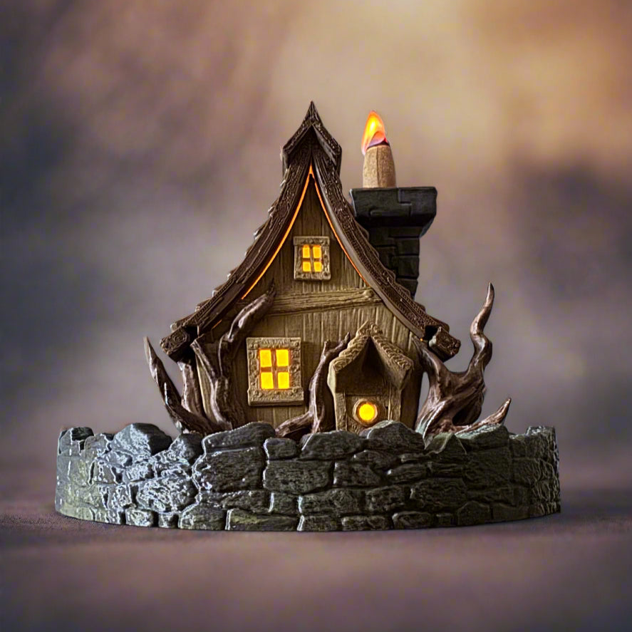 Decorative haunted house with glowing windows and a candle on a dark background
