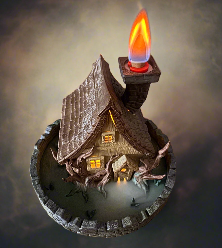Decorative house with a lit candle on a dark background