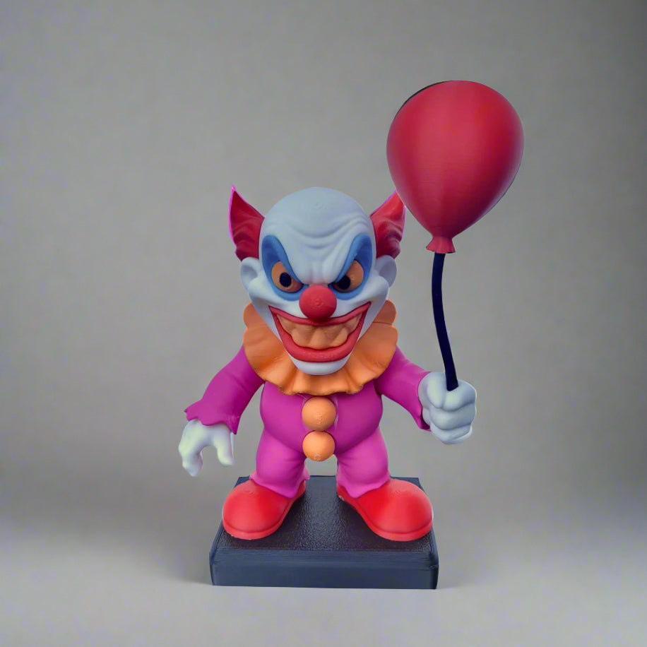 Colorful clown figurine with a red balloon on a gray background