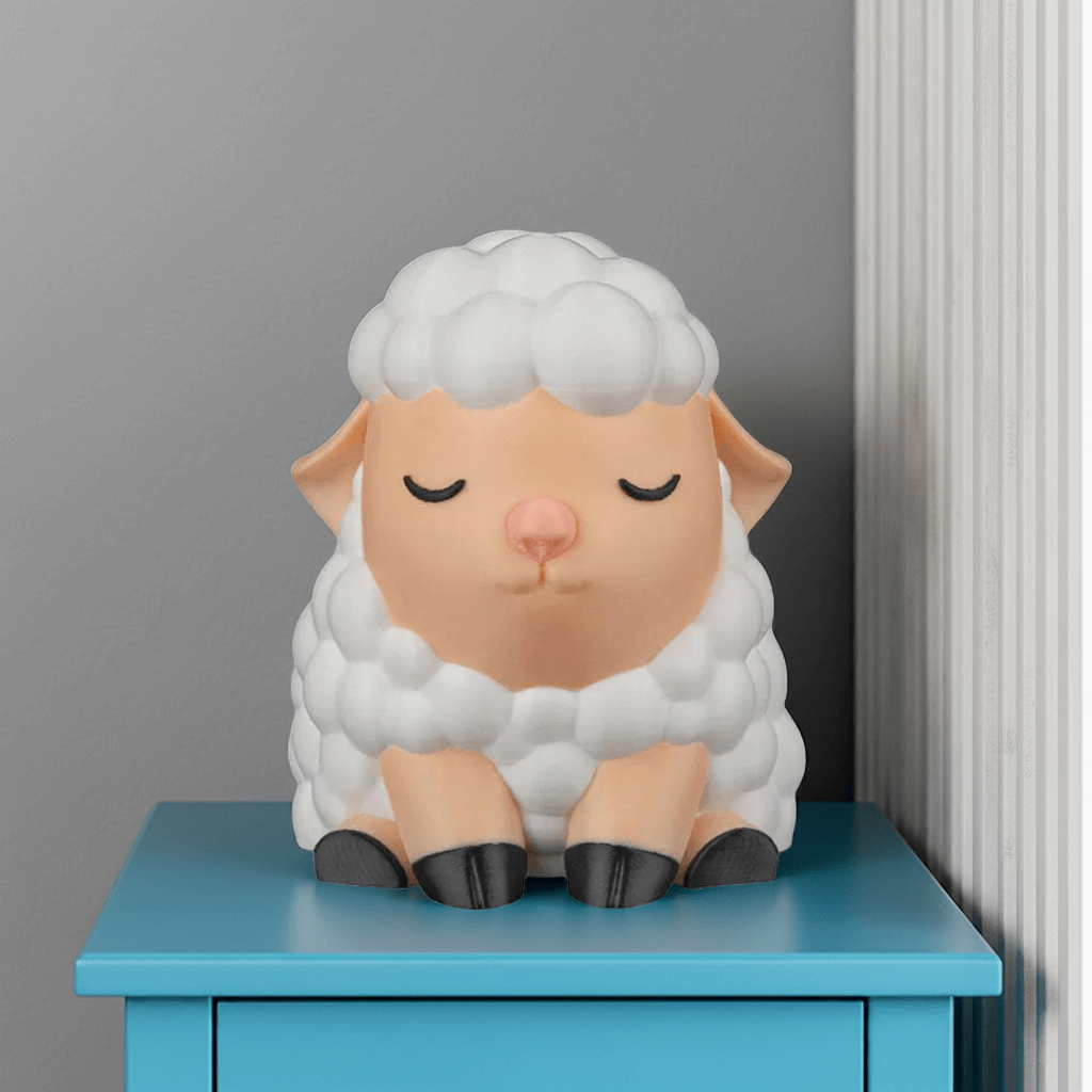 Sheep-shaped night light on a blue surface against a gray wall