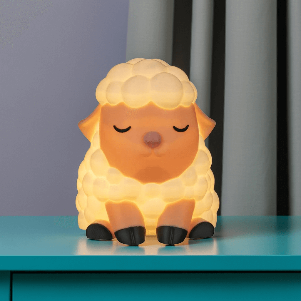 Sheep-shaped night light on a blue surface with a dark curtain background