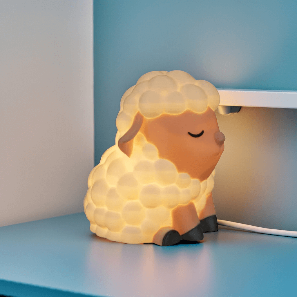 Sheep-shaped night light on a blue surface with a blurred background