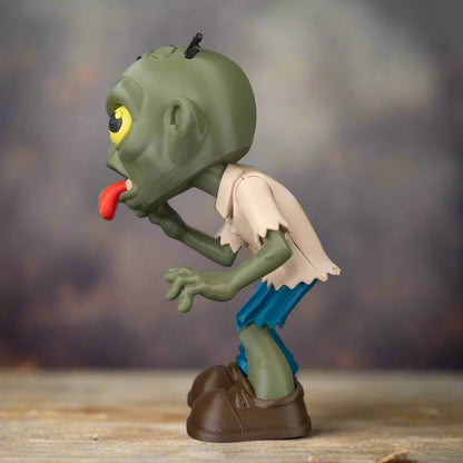 Green zombie figurine with a red tongue on a black background