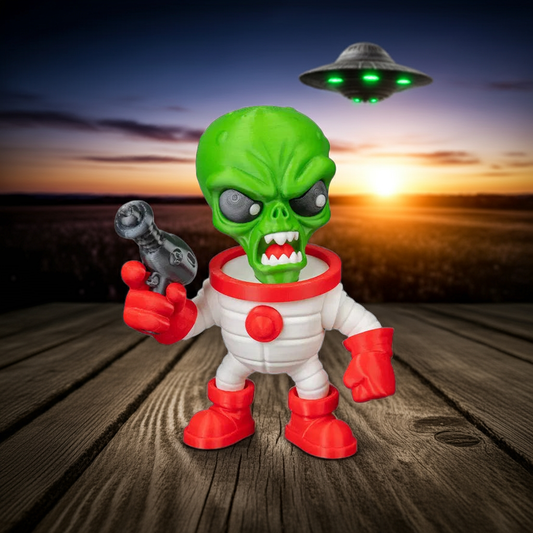 Toy figure of an alien holding a gun with a UFO in the background