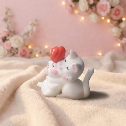 Two cat-shaped night lights on a soft surface with a floral and light background