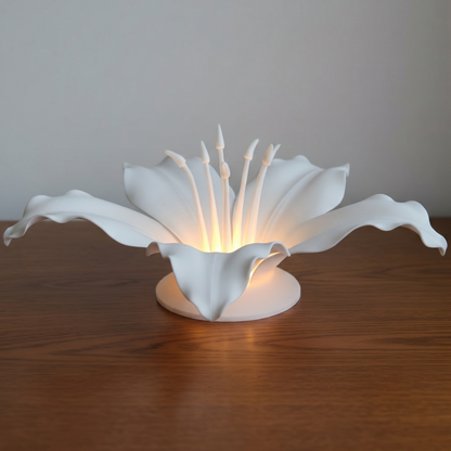 White flower-shaped lamp on a wooden surface with a plain background